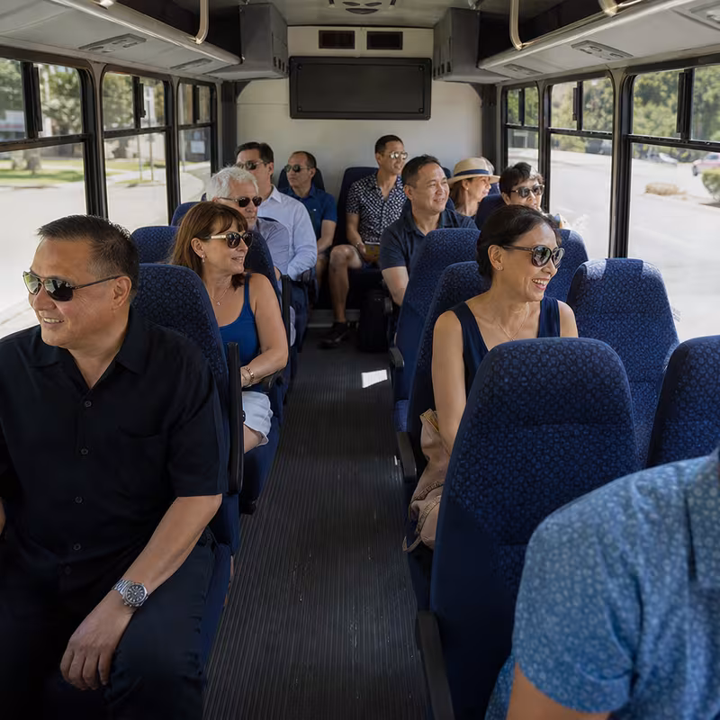 Group boarding a white charter bus for Private Event Transportation transportation in New Brunswick