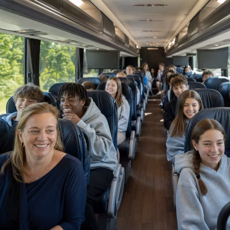 Group boarding a white charter bus for School Transportation transportation in New Brunswick